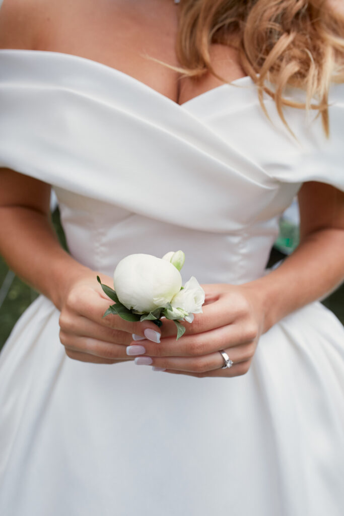 Bride holds in her arms little white boutonniere